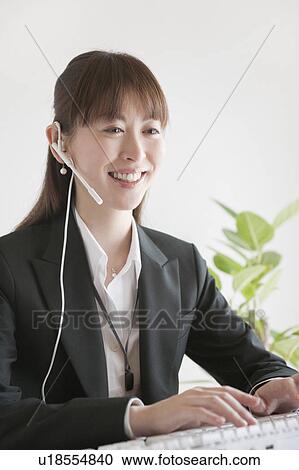 Stock Image - Businesswoman on headset. Fotosearch