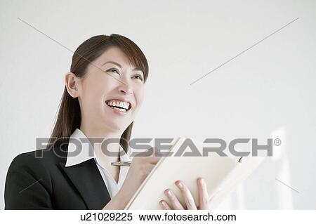 Stock Photography - Businesswoman writing on note pad. Fotosearch
