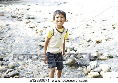 Stock Image - Cheerful Boy Playing in Stream. Fotosearch