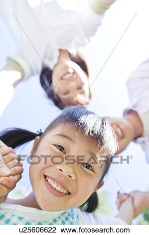 Family holding hands looking at camera View Large Photo Image Stock Image - Family holding hands looking at camera. Fotosearch