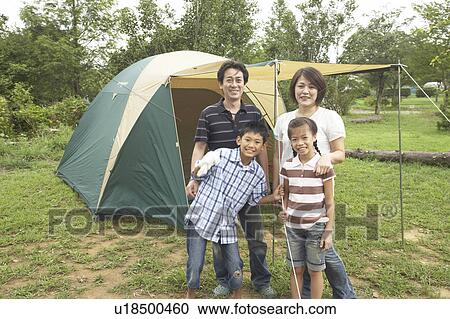Stock Image - Family in front of tent, Chiba Prefecture, Honshu, Japan. Fotosearch