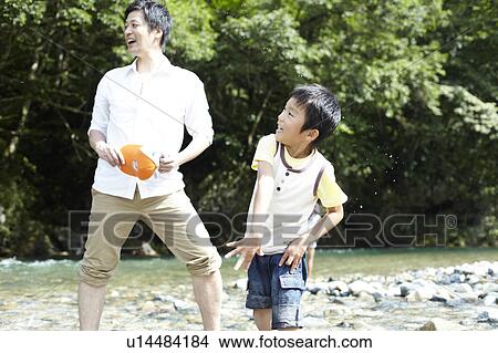 Picture - Father and Son Playing in River. Fotosearch