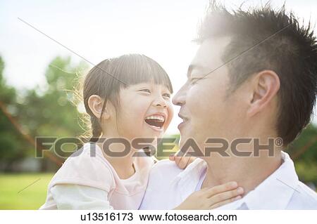 Stock Image - Father carrying daughter. Fotosearch