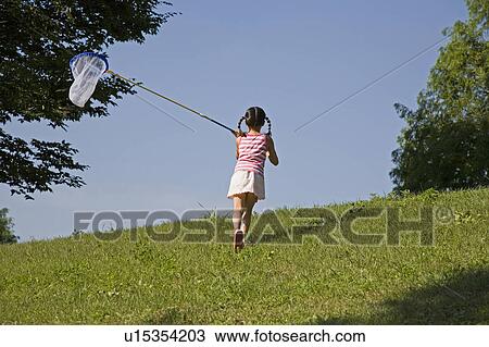 Stock Image - Girl Catching Butterflies. Fotosearch