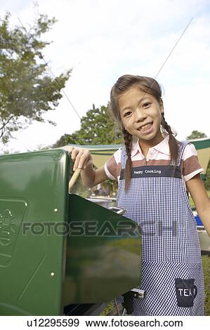 Stock Photo - Girl Cooking At Campsite. Fotosearch