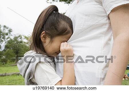Stock Image - Girl crying holding mother's shirt, Chiba Prefecture, Honshu, Japan. Fotosearch
