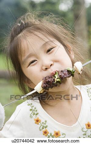 Girl eating kebab, Chiba Prefecture, Honshu, Japan View Large Photo Image Stock Image - Girl eating kebab, Chiba Prefecture, Honshu, Japan. Fotosearch
