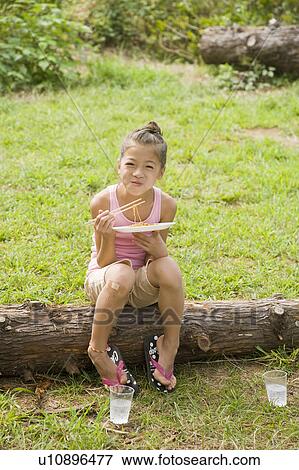Stock Photo - Girl eating Yakisoba (Fried Noodles), Chiba Prefecture, Honshu, Japan. Fotosearch