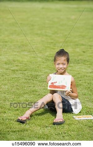 Stock Image - Girl holding a drawing, Chiba Prefecture, Honshu, Japan. Fotosearch