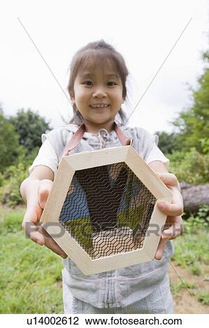 Stock Image - Girl holding cage for bugs, Chiba Prefecture, Honshu, Japan. Fotosearch