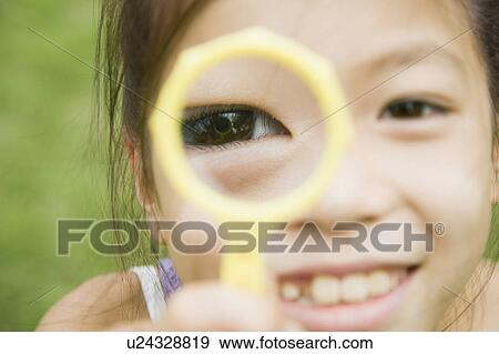 Stock Photo - Girl holding magnifying glass, Chiba Prefecture, Honshu, Japan. Fotosearch