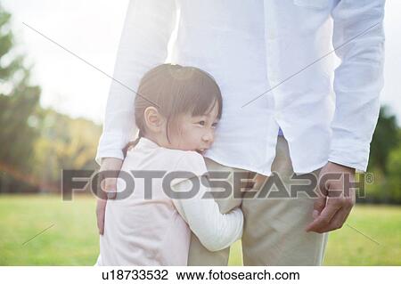 Stock Image - Girl hugging father's leg. Fotosearch