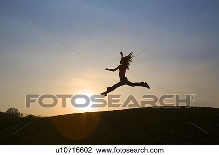 Stock Image - Girl Leaping in Sunset. Fotosearch