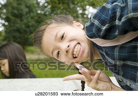Stock Image - Girl making a peace sign, Chiba Prefecture, Honshu, Japan. Fotosearch