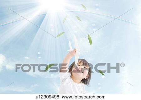 Stock Photo - Girl Playing with Paper Airplane. Fotosearch