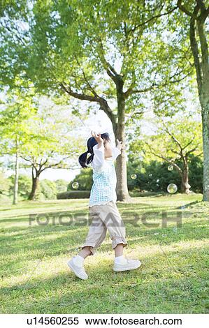 Girl running trying to catch bubbles View Large Photo Image Stock Photography - Girl running trying to catch bubbles. Fotosearch