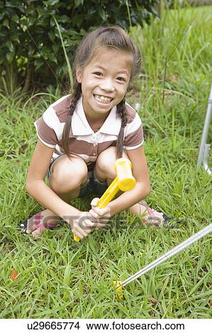 Picture - Girl setting up tent, Chiba Prefecture, Honshu, Japan. Fotosearch