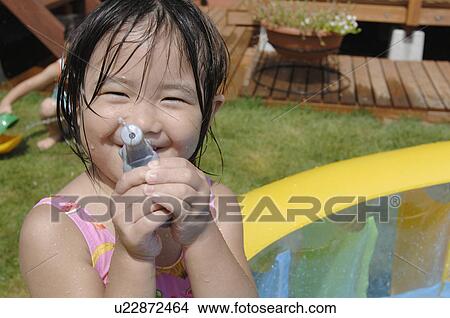 Girl shooting a water gun, Chiba Prefecture, Honshu, Japan View Large Photo Image Picture - Girl shooting a water gun, Chiba Prefecture, Honshu, Japan. Fotosearch