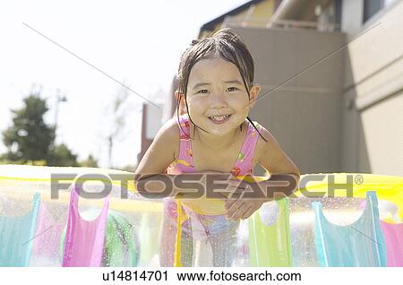 Stock Image - Girl standing in wading pool, Chiba Prefecture, Honshu, Japan. Fotosearch