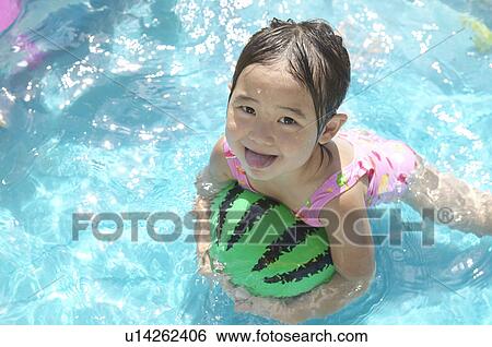 Stock Photograph - Girl swimming in wading pool, Chiba Prefecture, Honshu, Japan. Fotosearch