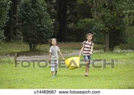 Stock Photo - Girls carrying a basket, Chiba Prefecture, Honshu, Japan. Fotosearch