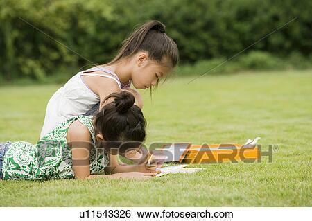 Stock Photograph - Girls drawing with crayons, Chiba Prefecture, Honshu, Japan. Fotosearch