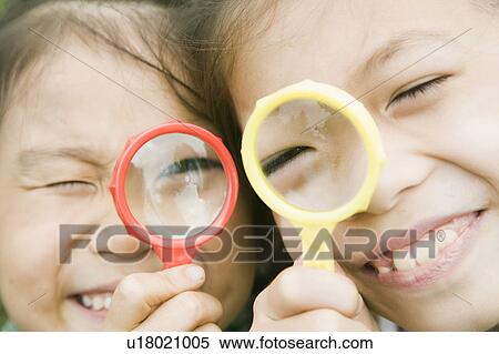 Stock Photography - Girls holding magnifying glass, Chiba Prefecture, Honshu, Japan. Fotosearch