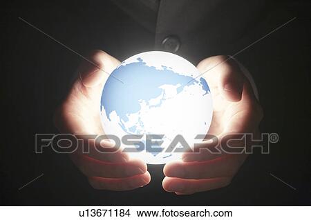 Picture - Globe floating in businessman's hands. Fotosearch
