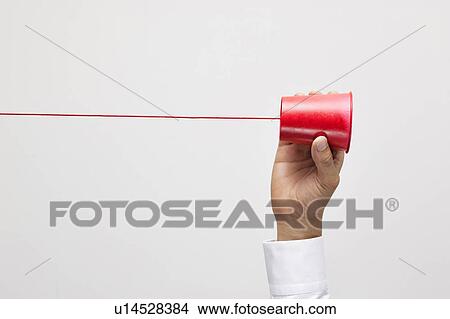 Picture - Hand holding tin can phone. Fotosearch