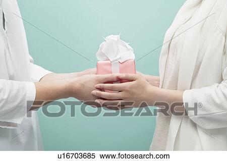 Hands holding a gift View Large Photo Image Stock Photography - Hands holding a gift. Fotosearch