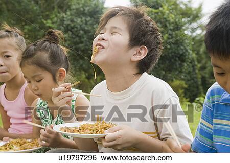 Stock Photograph - Kids eating Yakisoba (Fried Noodles), Chiba Prefecture, Honshu, Japan. Fotosearch