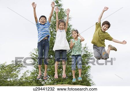 Stock Image - Kids jumping, Chiba Prefecture, Honshu, Japan. Fotosearch