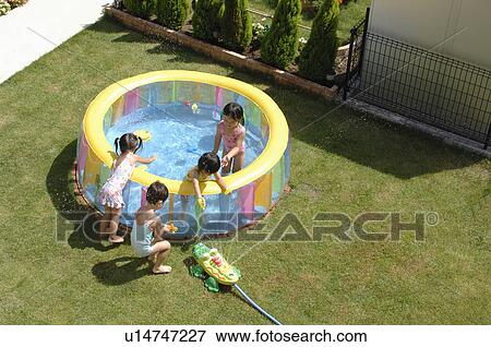 Stock Photo - Kids playing in wading pool, Chiba Prefecture, Honshu, Japan. Fotosearch