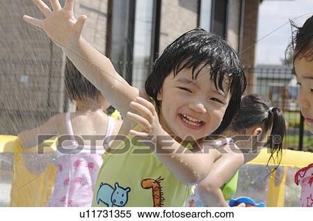 Stock Photography - Kids playing in wading pool, Chiba Prefecture, Honshu, Japan. Fotosearch