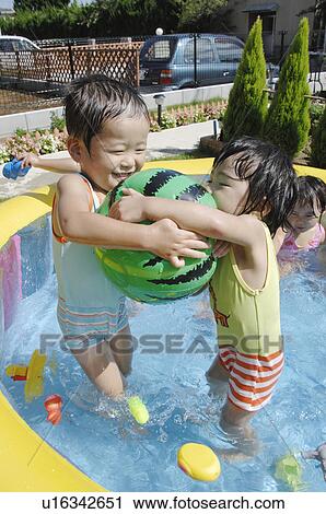 Stock Image - Kids playing with beach ball, Chiba Prefecture, Honshu, Japan. Fotosearch