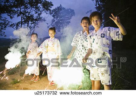 Stock Image - Kids playing with firework, Chiba Prefecture, Honshu, Japan. Fotosearch