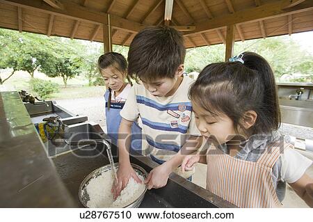 Stock Image - Kids washing rice, Chiba Prefecture, Honshu, Japan. Fotosearch