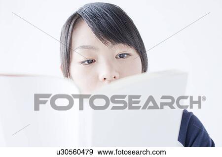 Stock Photo - Low Angle view of Teenage Girl Reading Book. Fotosearch
