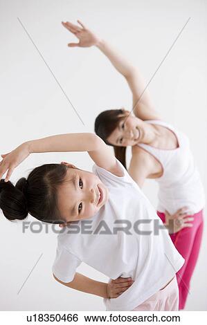 Stock Photograph - Mother and Daughter Stretching. Fotosearch