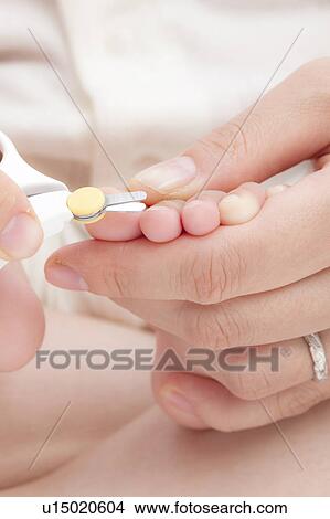 Picture - Mother Cutting Baby's Toenails. Fotosearch