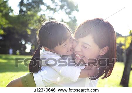 Mother giving daughter a piggyback ride View Large Photo Image Stock Photograph - Mother giving daughter a piggyback ride. Fotosearch