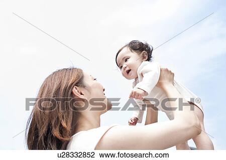 Stock Image - Mother lifting up baby. Fotosearch
