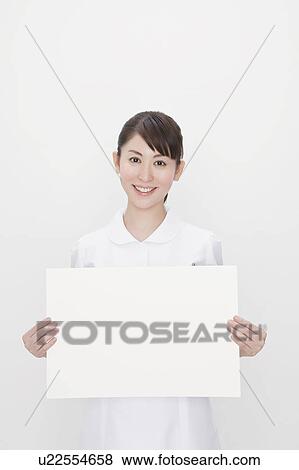 Nurse holding blank cardboard View Large Photo Image Stock Photo - Nurse holding blank cardboard. Fotosearch