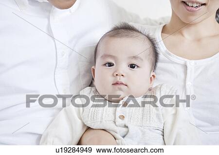 Stock Photo - Parents holding a baby. Fotosearch