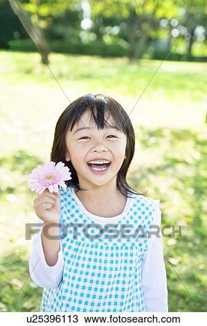Portrait of girl holding a gerbera View Large Photo Image Stock Image - Portrait of girl holding a gerbera. Fotosearch