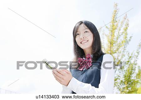Schoolgirl Using Phone Outdoors View Large Photo Image Stock Image - Schoolgirl Using Phone Outdoors. Fotosearch