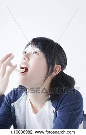 Stock Image - Teenage Girl Eating Crisps. Fotosearch
