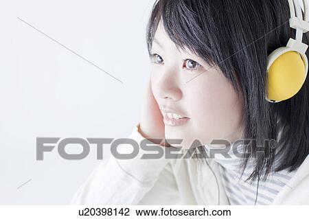 Stock Image - Teenage Girl Listening To Headphones. Fotosearch