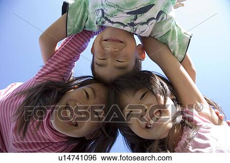 Stock Photograph - Three Children Huddling. Fotosearch