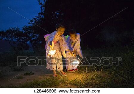 Stock Photograph - Two Girls in Kimonos Holding Sparkles. Fotosearch